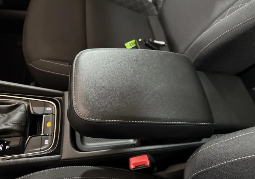 Accoudoir central noir en cuir avec coutures grises, entouré des sièges avant du Skoda Karoq 1.5 TSI 2021.