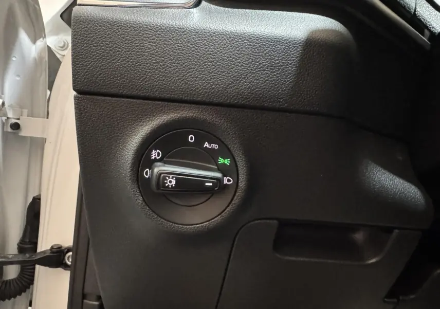 Gros plan sur le bouton de commande des phares du côté gauche d’un Skoda Karoq blanc 2021.
