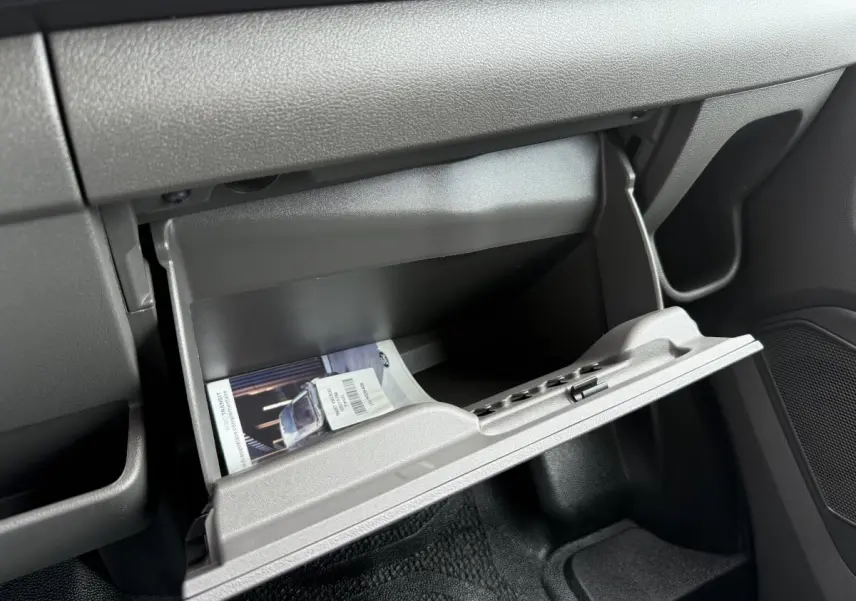 Vue intérieure du tableau de bord du Ford Transit Fourgon 2024, boîte à gants ouverte avec notice visible.