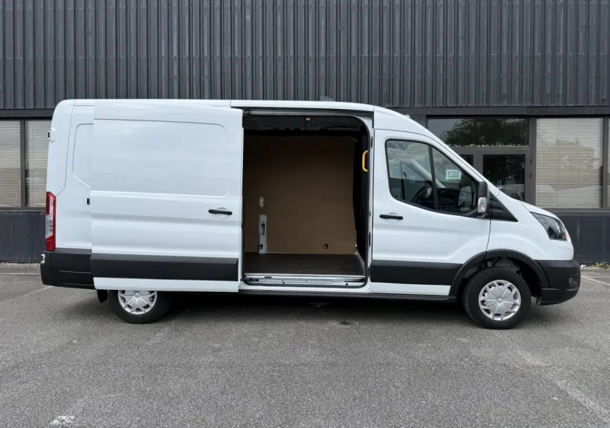 Ford Transit Fourgon blanc vu de profil droit avec porte latérale coulissante ouverte montrant l’espace de chargement.