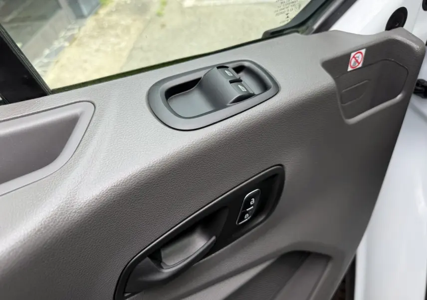 Détail de la porte côté conducteur du Ford Transit Fourgon blanc 2024 avec commandes de vitres et verrouillage.