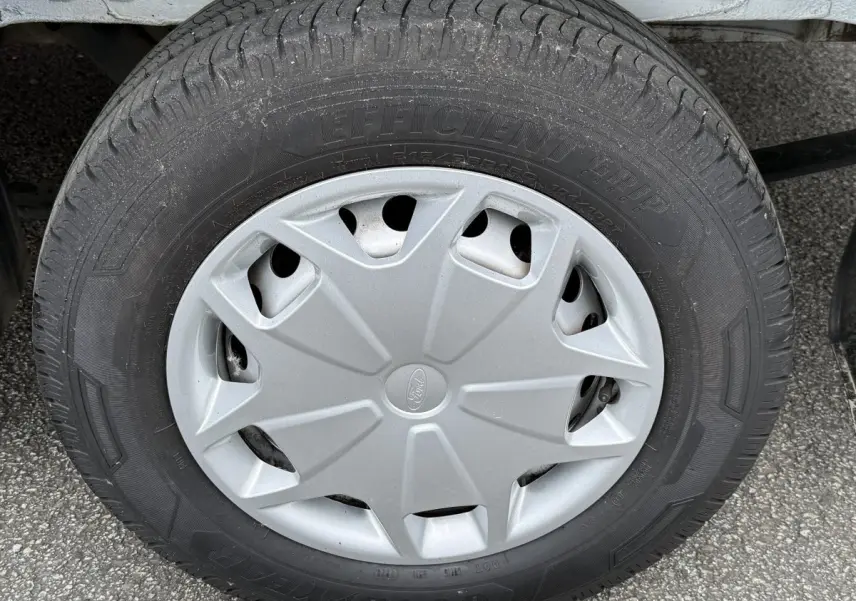 Gros plan sur la roue avant droite du Ford Transit Fourgon blanc, avec enjoliveur gris et pneu Goodyear.