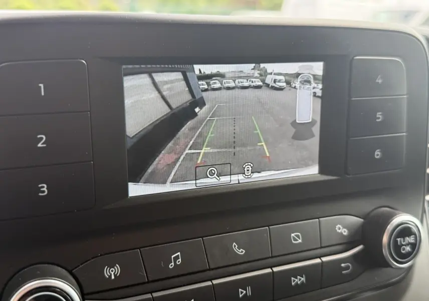 Écran de caméra de recul du Ford Transit Fourgon blanc, vue arrière avec lignes de guidage colorées.