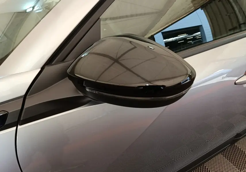 Rétroviseur noir en gros plan côté gauche sur Peugeot E-2008 électrique gris clair 2023.