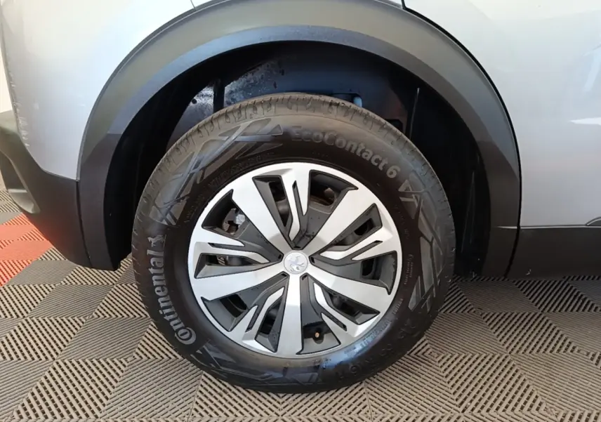 Gros plan sur la roue avant gauche gris clair du Peugeot E-2008 électrique avec jante en alliage et pneu Continental.