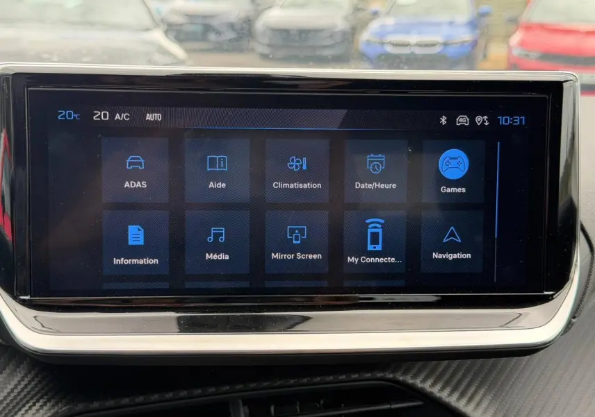 Écran tactile central de la Peugeot 208 2025, affichant le menu principal avec icônes bleues sur fond noir.