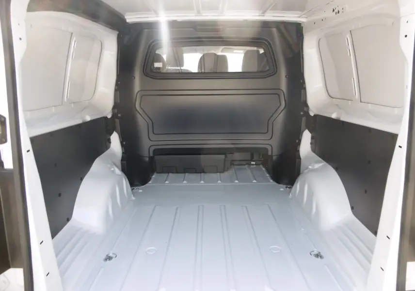 Vue intérieure arrière du Peugeot Expert Long blanc, montrant l'espace de chargement vide avec parois blanches et protections noires.
