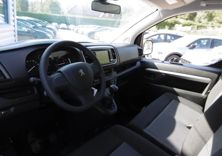 Intérieur du Peugeot Expert Long blanc 2023, vue côté conducteur, tableau de bord noir avec écran tactile et volant Peugeot.