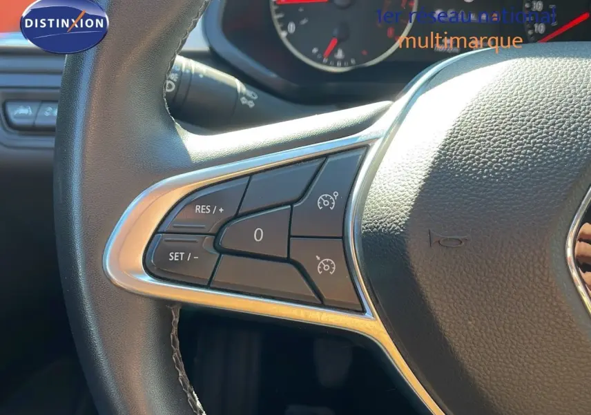 Gros plan sur le volant cuir noir du Renault Captur TCE 100CH Corporate Edition, avec commandes de régulateur de vitesse.