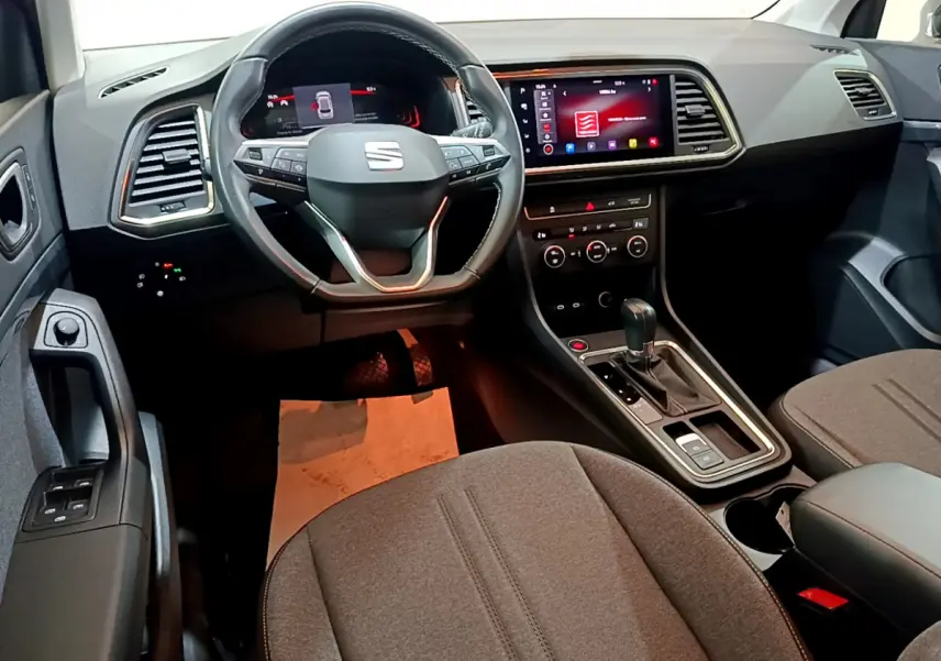 Intérieur du SEAT Ateca 2022 vu de face, tableau de bord moderne avec écran tactile et volant multifonction noir.