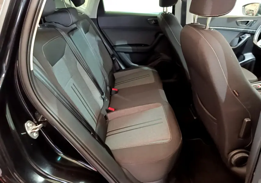Vue intérieure côté gauche sur la banquette arrière grise et noire du SEAT Ateca noir 2022 avec détails des sièges et portière ouverte.