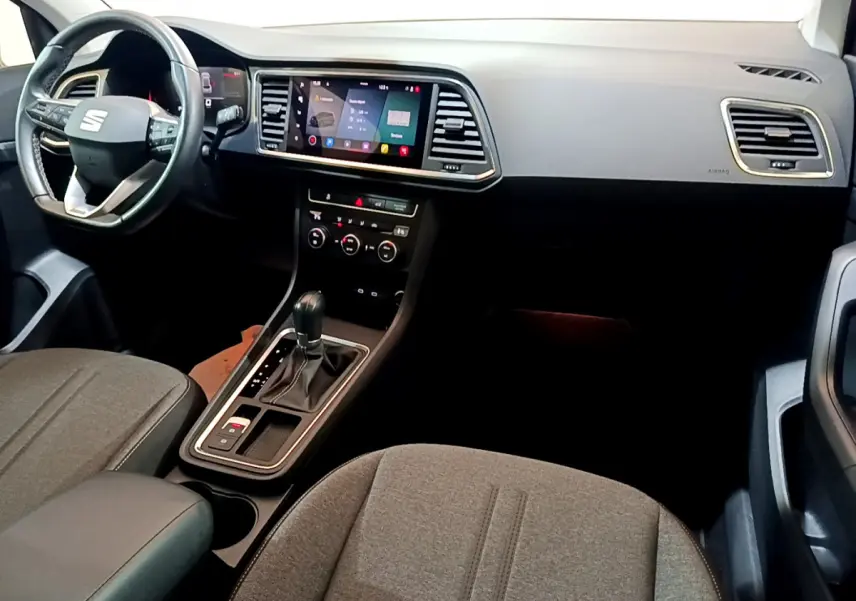 Intérieur avant du SEAT Ateca 2022, vue côté conducteur, tableau de bord noir avec écran tactile central et volant multifonctions.