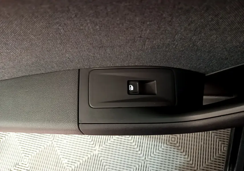 Bouton de verrouillage des portes noir sur la garniture intérieure de la portière d'un SEAT Ateca noir, vue rapprochée.