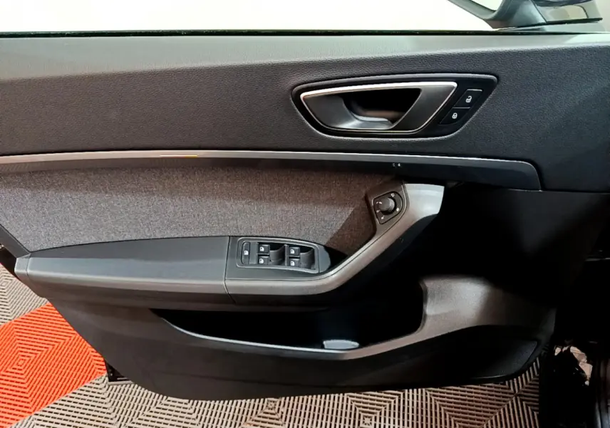 Gros plan sur la porte côté conducteur du SEAT Ateca noir, montrant les commandes de vitres et de rétroviseurs.