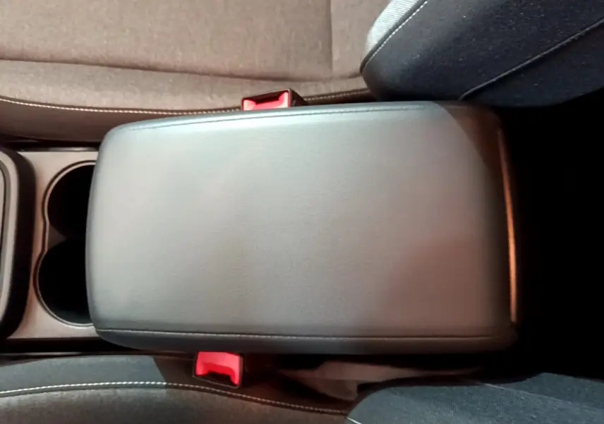 Vue rapprochée du couvercle de la console centrale noire entre les sièges avant du SEAT Ateca 2022.