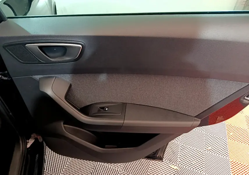 Intérieur montrant la porte côté gauche du SEAT Ateca noir avec poignée et commande de vitre électrique.
