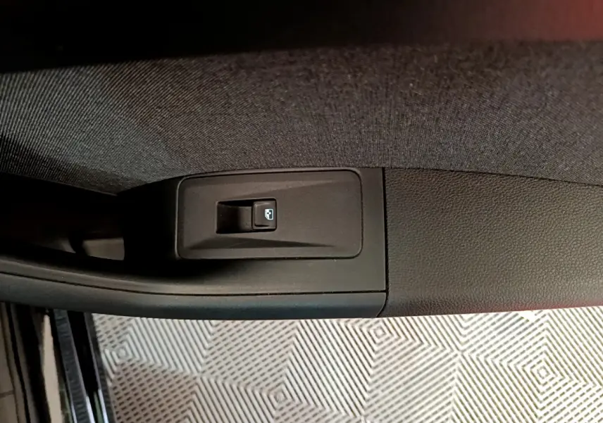 Bouton de commande de lève-vitre arrière droit sur la porte intérieure d'un SEAT Ateca noir 2022.