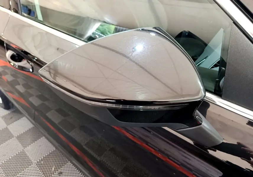 Rétroviseur côté gauche noir brillant du SEAT Ateca 2022 avec clignotant intégré, vue rapprochée en intérieur.