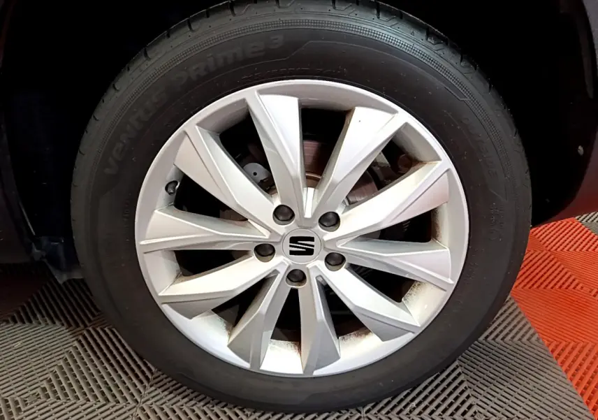 Gros plan sur la roue avant droite avec jante argentée du SEAT Ateca noir 2022.