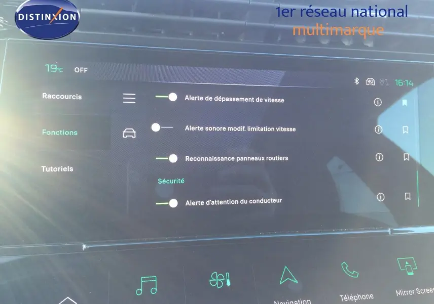 Vue de face du tableau de bord numérique de la Peugeot 308 gris Artense, affichant les alertes de sécurité et fonctions connectées.