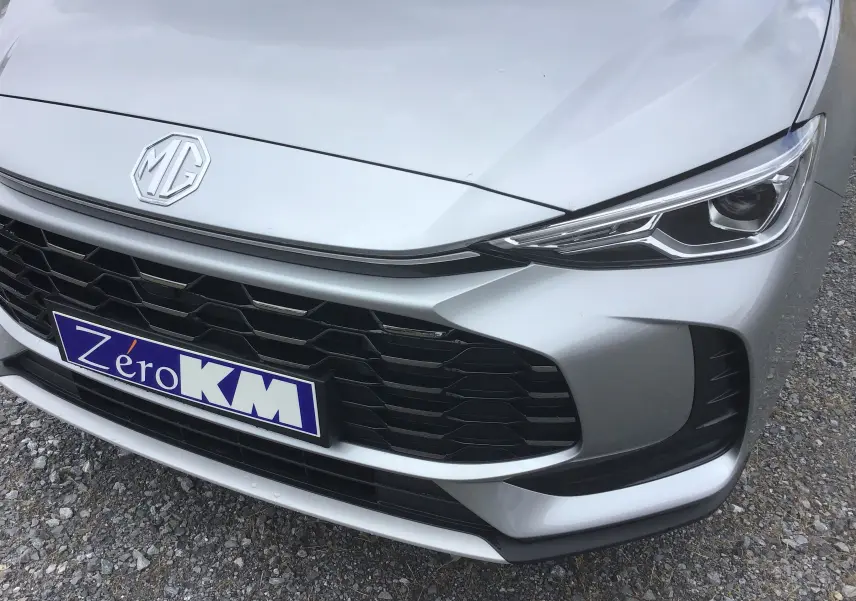 Gros plan sur l'avant droit du MG ZS Cosmic Silver avec calandre noire et phares LED fins.