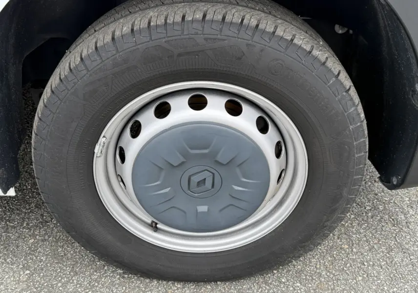 Gros plan sur la roue avant droite du Renault Master blanc, avec jante acier et logo Renault central gris.