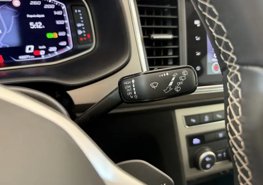 Gros plan sur la commande d’essuie-glace à gauche du volant dans l’habitacle du SEAT Ateca gris clair 2023.