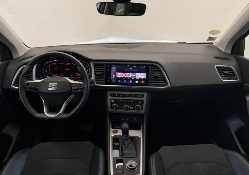 Intérieur noir du SEAT Ateca 2023 vu de face, avec tableau de bord digital et écran tactile central lumineux.