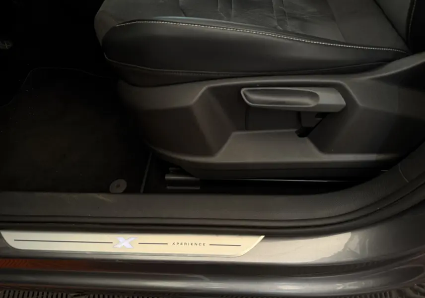 Gros plan sur la marche d'entrée côté conducteur du SEAT Ateca gris clair version Xperience avec logo lumineux Xperience.