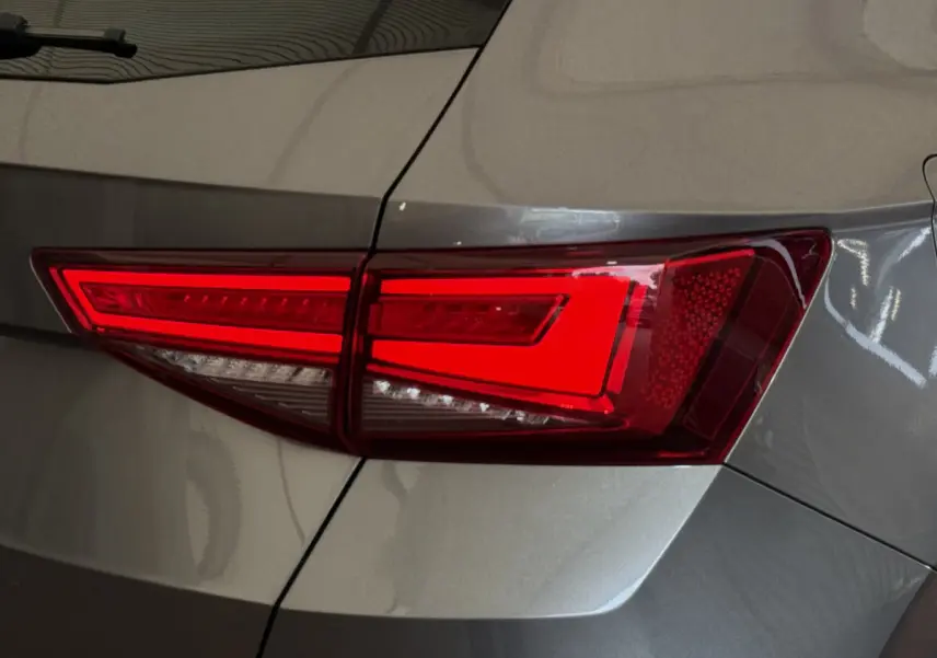 Gros plan sur le feu arrière droit rouge d’un SEAT Ateca gris clair 2023, soulignant ses lignes nettes et modernes.
