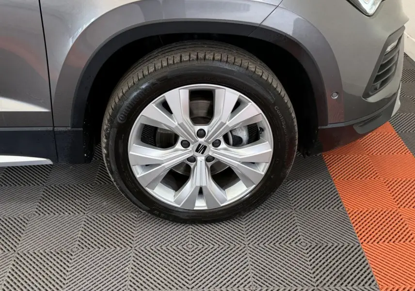 Gros plan sur la roue avant droite gris clair du SEAT Ateca 2023 avec jante alliage et logo central visible.