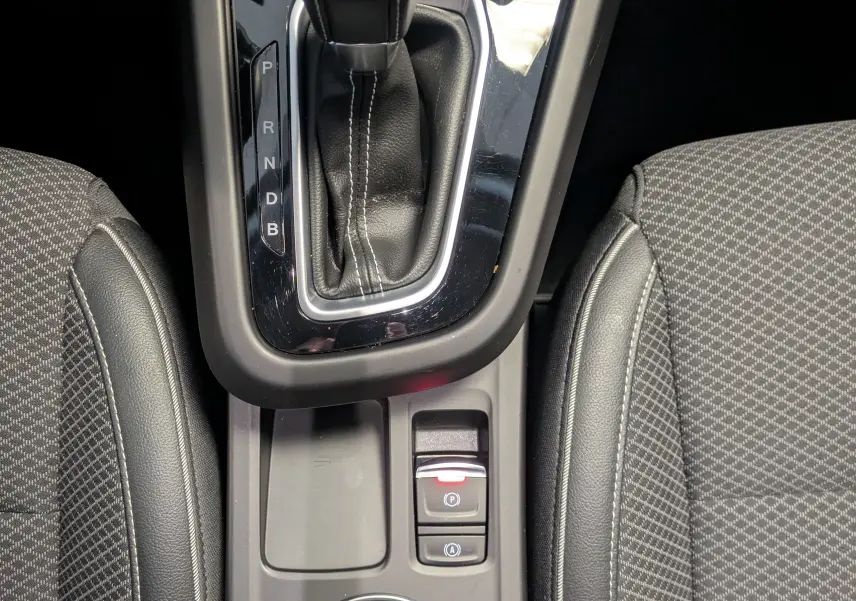 Vue plongeante sur la console centrale de la Renault Arkana 2023, boîte auto noire avec surpiqûres blanches.