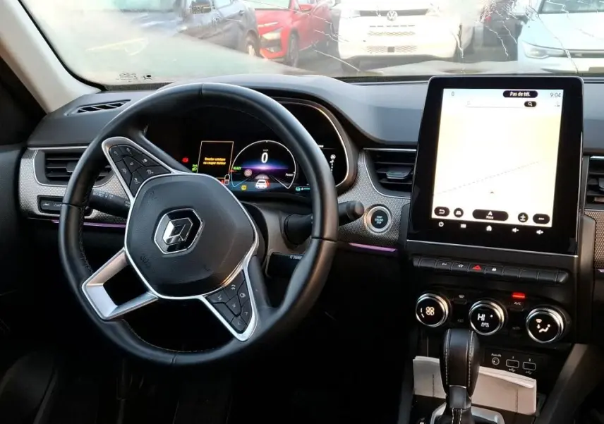 Vue 3/4 arrière droite d’un Renault Arkana noir métal 2023, avec feux arrière LED et jantes bi-ton visibles en showroom.