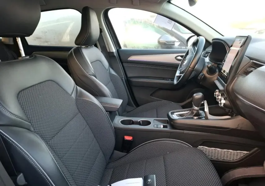 Gros plan sur l'aile avant droite noire métallisée du Renault Arkana 2023, mettant en valeur la roue et l'arche de passage.