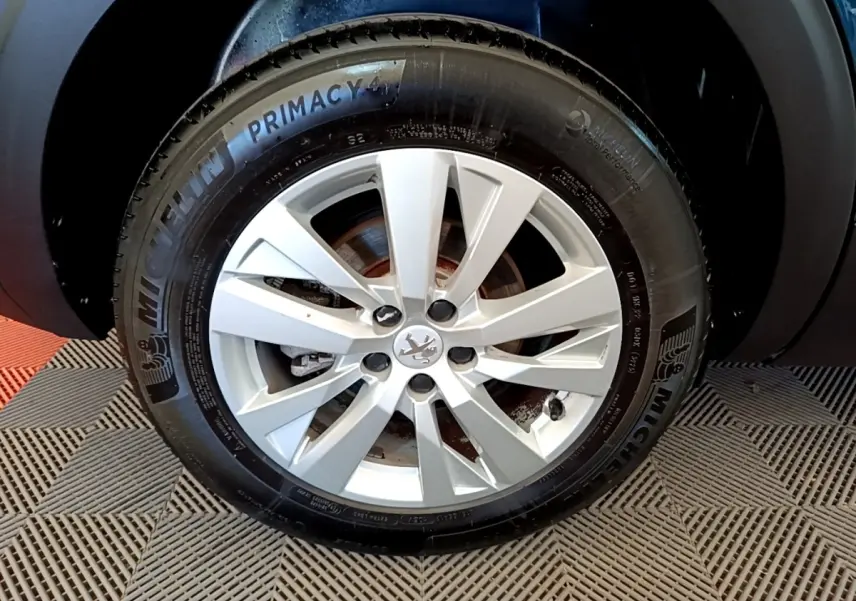 Gros plan sur la roue avant droite du Peugeot 5008 bleu, avec jante alliage et pneu Michelin Primacy 4.