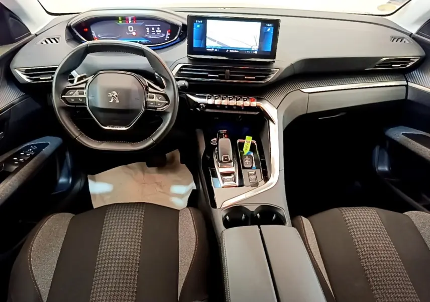 Vue intérieure avant du Peugeot 5008 2021 avec tableau de bord numérique et volant cuir multifonctions noir.