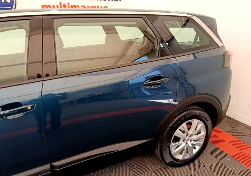 Vue latérale droite du Peugeot 5008 bleu 2021, mettant en valeur la porte arrière et la roue arrière.
