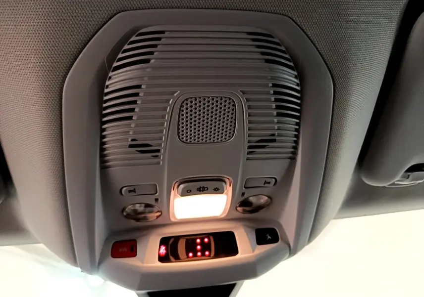 Vue en contre-plongée du plafonnier intérieur gris du Peugeot 5008 bleu avec éclairage et commandes intégrées.