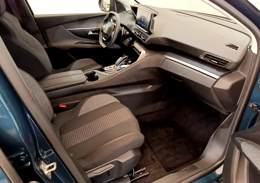 Vue intérieure côté conducteur du Peugeot 5008 bleu 2021, avec volant cuir multifonctions et écran tactile central.