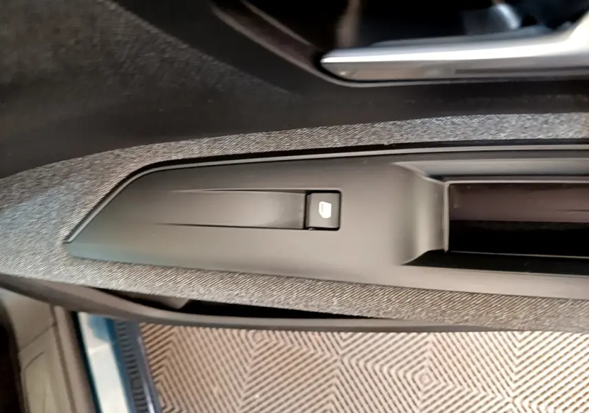 Détail de la commande de verrouillage de porte sur la portière côté conducteur d’un Peugeot 5008 bleu.