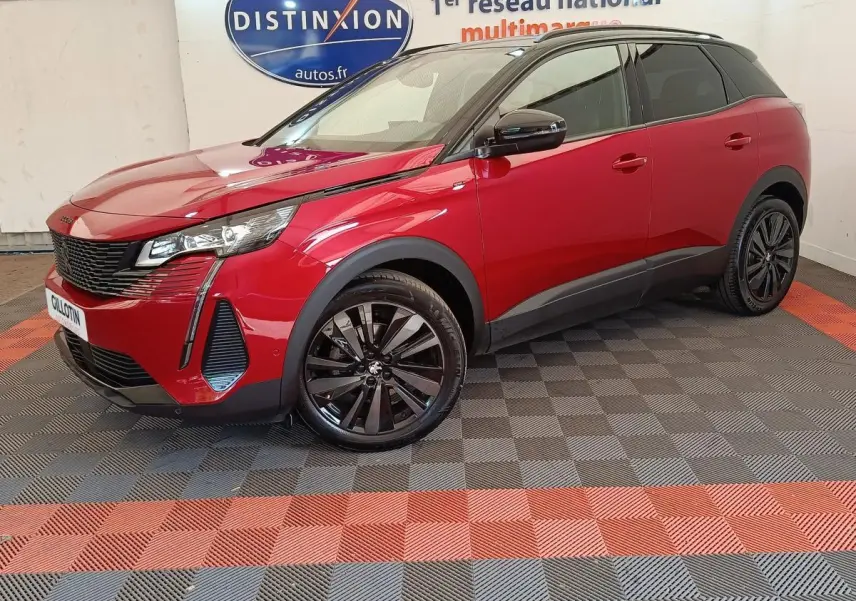 Peugeot 3008 rouge vue 3/4 avant droit, jantes noires et toit noir contrasté dans un showroom.