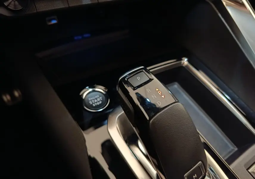 Gros plan sur la commande de boîte automatique noire et bouton start/stop dans l’habitacle du Peugeot 3008 rouge.