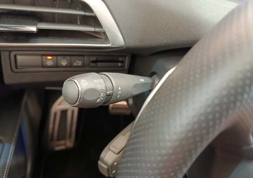 Gros plan sur la commande des phares et clignotants côté gauche du volant du Peugeot 3008 rouge GT Pack 2022.