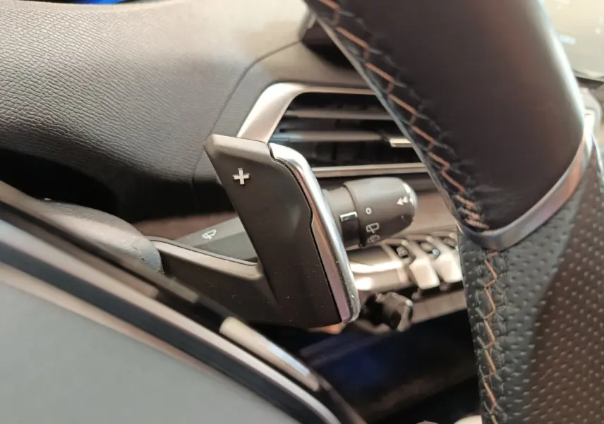 Gros plan sur la palette de changement de vitesse droite en cuir noir avec surpiqûres orange du Peugeot 3008 GT Pack rouge.