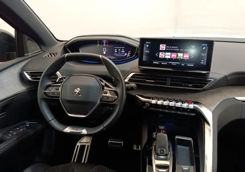 Vue intérieure avant du tableau de bord du Peugeot 3008 GT Pack 2022 avec volant compact et écran tactile central.