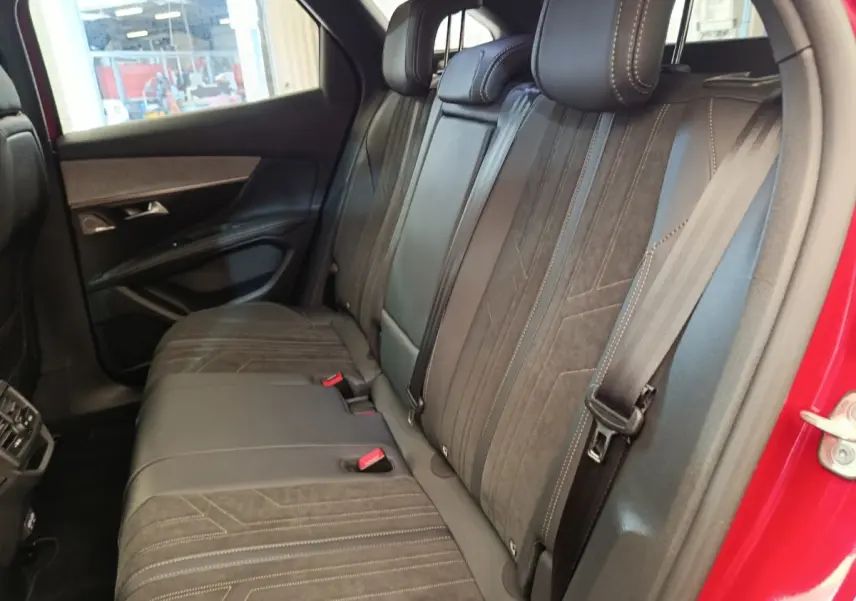 Vue intérieure côté droit des sièges arrière en cuir noir du Peugeot 3008 GT Pack rouge, avec ceinture de sécurité visible.