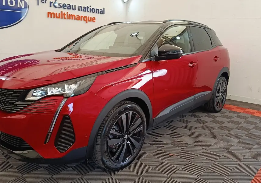 Peugeot 3008 rouge vue 3/4 avant droit, avec jantes noires et toit noir contrasté en intérieur showroom.