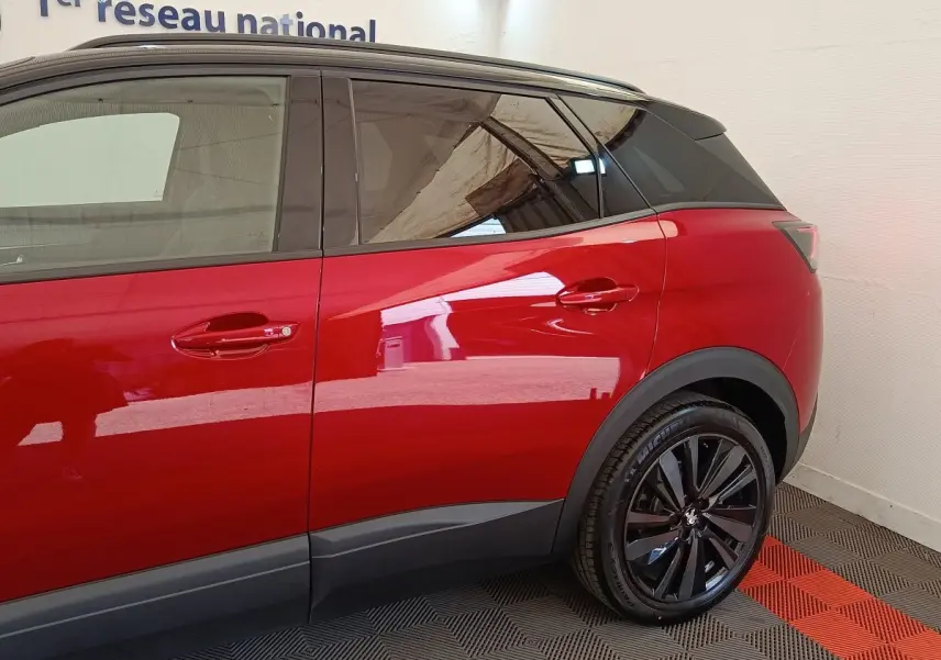 Vue latérale droite sur le Peugeot 3008 rouge, mettant en valeur les jantes noires et les vitres teintées.