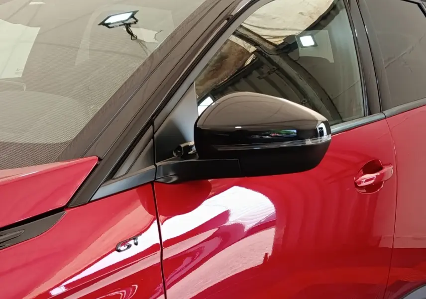 Détail du rétroviseur noir et porte rouge côté conducteur du Peugeot 3008 GT Pack 2022.