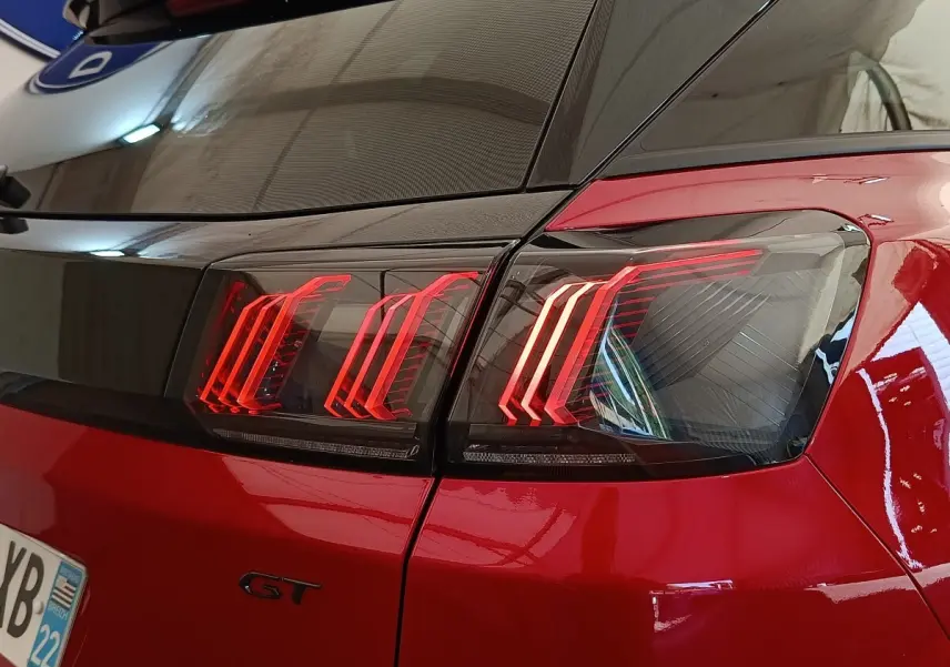 Gros plan sur le feu arrière droit rouge brillant d’un Peugeot 3008 GT Pack 2022 avec logo GT visible.